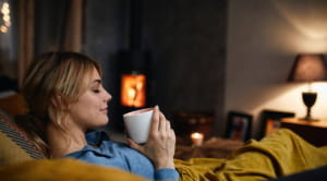 Woman relaxing on sofa with hot drink